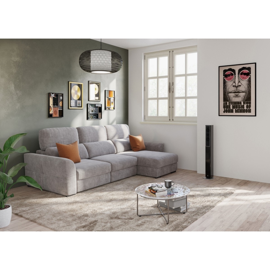 Rohová sedačka stojí v obývacej izbe. Na konferenčnom stolíku sú knihy a hrnček. Na stene visí plagát s Johnom Lennonom s textom: „An Evening with the Music of John Lennon.“