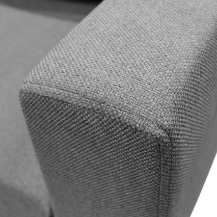 Rohová sedačka sivomodrej farby s viacerými vankúšmi je umiestnená na čiernom podstavci pred bielym pozadím. Sedačka je zobrazená zo zadnej strany.