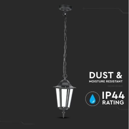 Čierna závesná lampa visí na reťazi. Je vyrobená z kovu a má štvorcový tvar s priehľadnými bočnými panelmi. Lampa je označená ako odolná voči prachu a vlhkosti, s krytím IP44.
