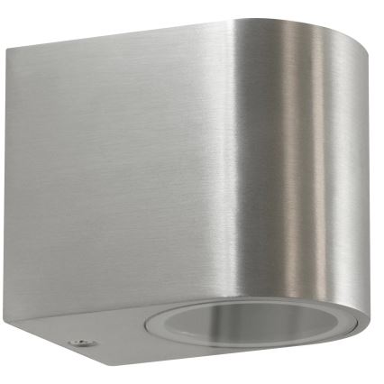 Kovové nástenné svietidlo svieti. Je vyrobené z brúseného kovu, obdĺžnikového tvaru s zaoblenými rohmi. Svietidlo je pripevnené na stenu.