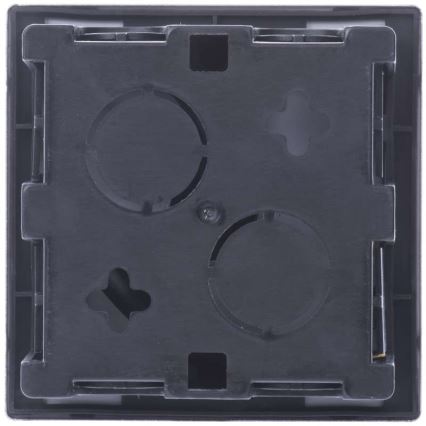 Čierna nástenná zásuvka s tromi otvormi a jedným menším otvorom v tvare kríža je pripravená na inštaláciu. Vizuálne je viditeľná zadná strana.