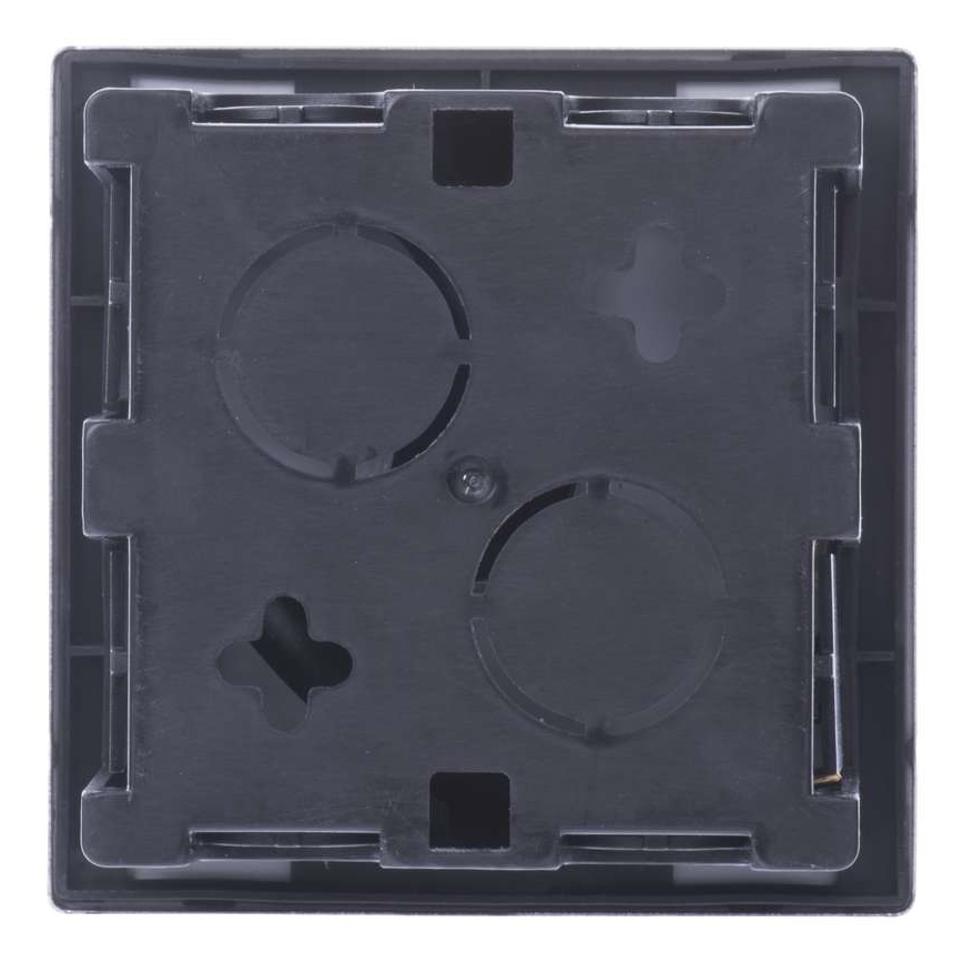 Čierna nástenná zásuvka s tromi otvormi a jedným menším otvorom v tvare kríža je pripravená na inštaláciu. Vizuálne je viditeľná zadná strana.