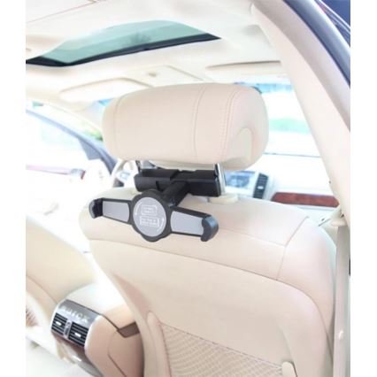 Držiak na tablet je pripevnený na opierku hlavy zadného sedadla auta. Držiak umožňuje upevnenie tabletu. Auto má svetlú béžovú koženkovú výplň sedadiel.