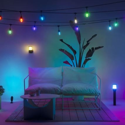 Dvojmiestna sedačka osvetlená farebnými svetlami. Za ňou je rastlina v kvetináči a girlanda svetielok. Na zemi je konferenčný stolík. Bočné osvetlenie dopĺňajú stojace lampy.