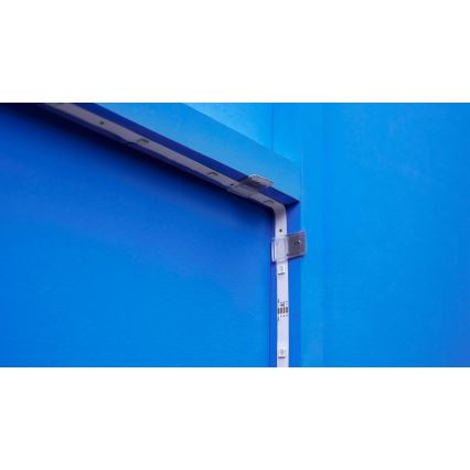 LED pásik sa pripevňuje na modrú stenu pomocou priehľadných plastových držiakov. Pásik je pripevnený k drevenému rámu.