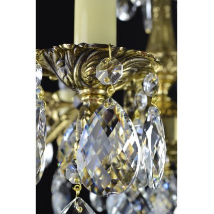Krištáľové lustre visia z ozdobného kovového ramena. Zlato-farebné kovové prvky držia visiace krištáľové prívesky rôznych veľkostí.