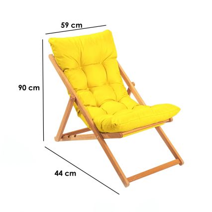 Skladacia ležadlová stolička s výškou 90 cm, šírkou 59 cm a hĺbkou 44 cm, má drevenú konštrukciu a žltý textilný vankúš. Stolička je zložená a je zobrazená na bielom pozadí.