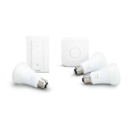 Tri biele LED žiarovky Philips a stmievač s dotykovým ovládaním sú položené na bielej ploche. Okrem toho je tam aj štvorcový bezdrôtový prepínač.