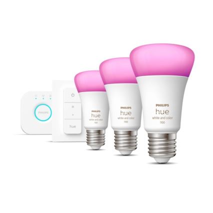 Tri inteligentné žiarovky Philips Hue, svietiace ružovo, sú umiestnené vedľa seba. Súčasťou sady je aj diaľkový ovládač a malá základňa. Na žiarovkách je uvedené: PHILIPS hue white and color 1100.