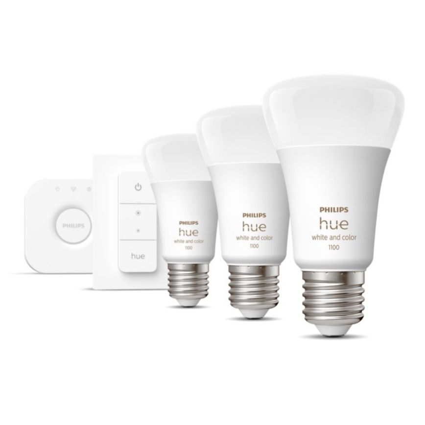 Tri inteligentné žiarovky Philips Hue s označením „white and color 1100“ a jeden ovládač sú umiestnené na bielom pozadí.