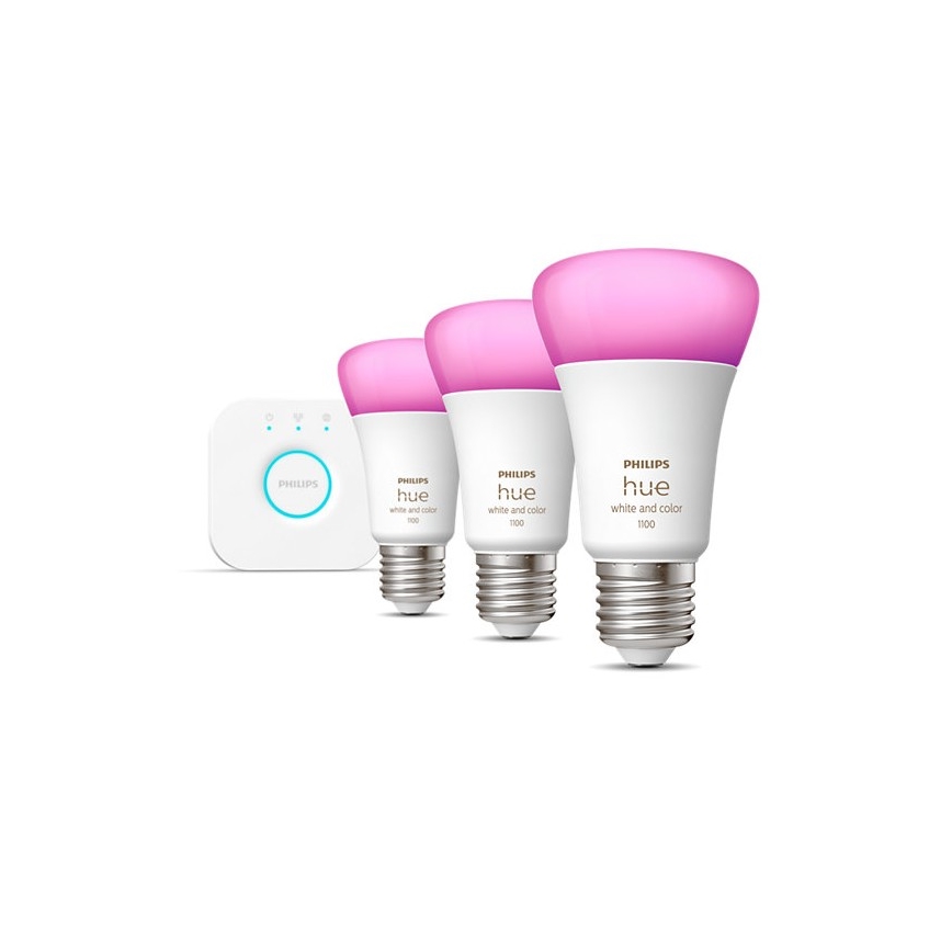 Tri LED žiarovky Philips Hue, biele a farebné, svietia ružovo. Sú umiestnené vedľa malého bieleho ovládača.