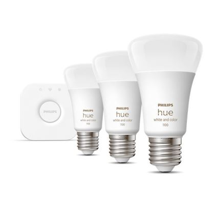 Tri LED žiarovky Philips Hue, rôznych veľkostí, s označením „white and color“, sú umiestnené na bielom pozadí. Najväčšia žiarovka má označenie 1100, stredná 1100 a najmenšia 100. Vedľa je malá biela ovládacia jednotka Philips.