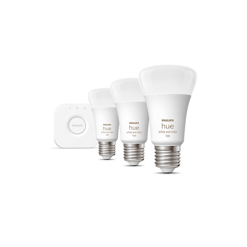 Tri LED žiarovky Philips Hue, rôznych veľkostí, s označením „white and color“, sú umiestnené na bielom pozadí. Najväčšia žiarovka má označenie 1100, stredná 1100 a najmenšia 100. Vedľa je malá biela ovládacia jednotka Philips.