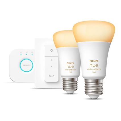 Dve inteligentné žiarovky Philips Hue white ambiance 1100 svietia slabou žltou farbou. Sú umiestnené vedľa diaľkového ovládača a stmievača.