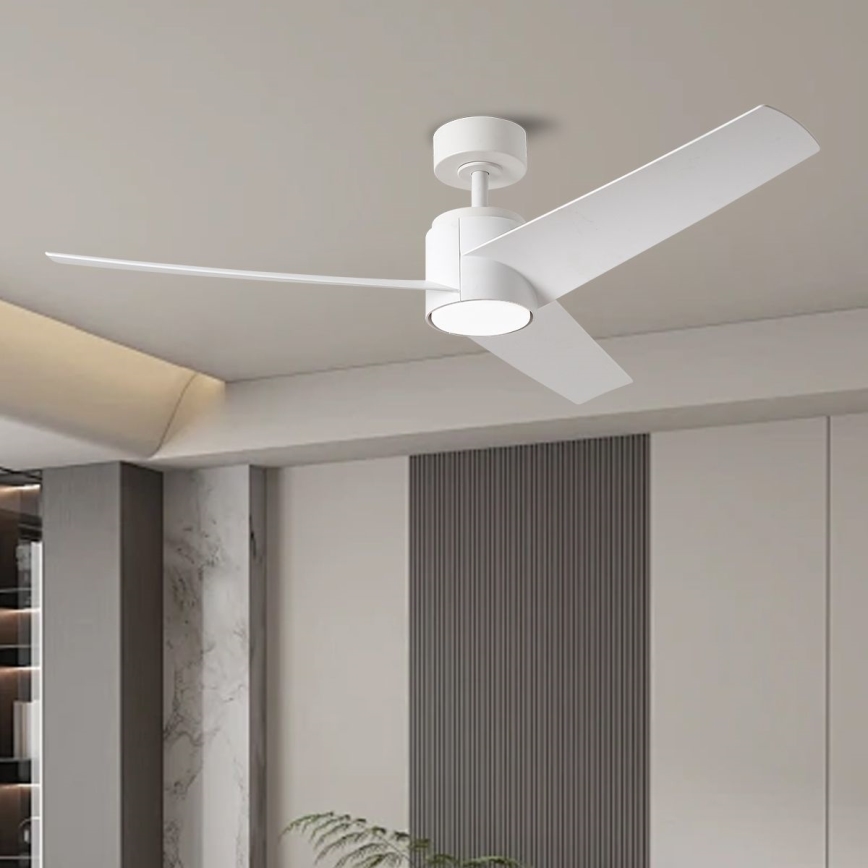 Biely stropný ventilátor s tromi lopatkami sa otáča v moderne zariadenej miestnosti s vysokým stropom a svetlými stenami. Ventilátor má zabudované svetlo.