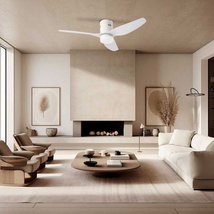 Biely stropný ventilátor s tromi lopatkami rotuje v modernej obývacej izbe s krémovou sedačkou, dvoma kreslami a nízkym dreveným stolíkom pred krbom.