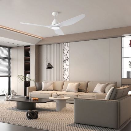 Biely stropný ventilátor s troma lopatkami sa otáča v modernej obývacej izbe s béžovou sedačkou, konferenčným stolíkom a kobercom.