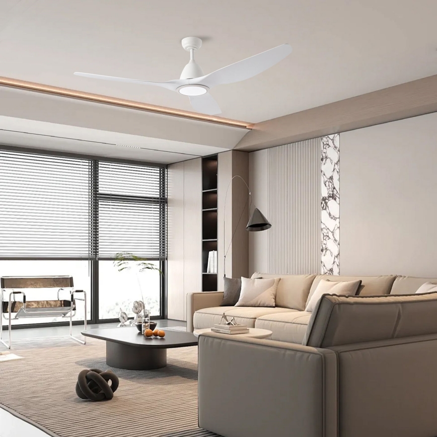 Biely stropný ventilátor s tromi lopatkami sa nachádza v modernej obývacej izbe s rozsiahlym oknom, pohovkou a kávovým stolíkom.