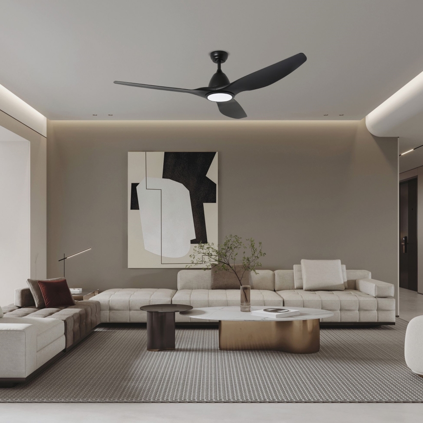 Čierny stropný ventilátor s integrovaným svetlom rotuje v modernej obývacej izbe s bielou sedačkou a konferenčným stolíkom. Izba má neutrálnu farebnú paletu a abstraktný obraz na stene.