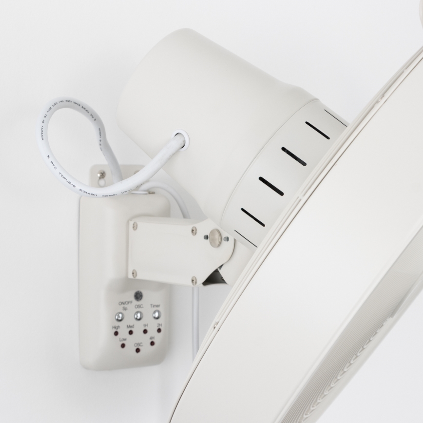 Biely nástenný ventilátor s osvetlením je pripevnený na stene. Ventilátor má ovládač s funkciami: ON/OFF, Sp, OSC, Timer, High, Med, Low, a časovačom s nastavením na 2, 4 a 6 hodín.