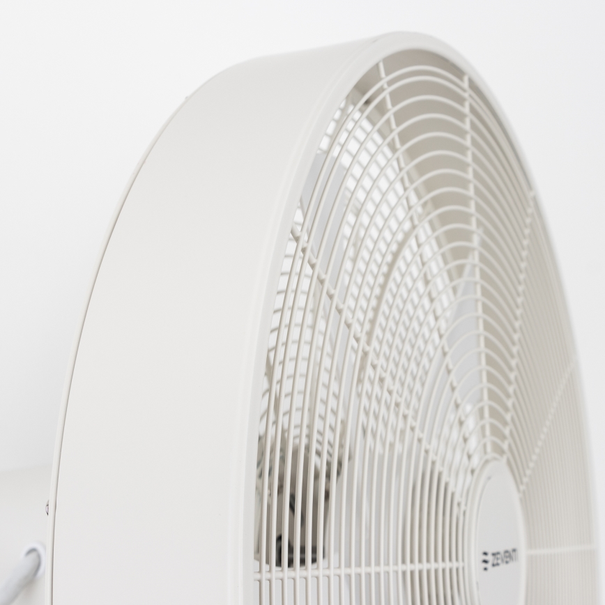 Biely stolový ventilátor s ochrannou mriežkou sa nachádza pred bielym pozadím. Ventilátor je v nehybnom stave. Na spodnej časti je viditeľné logo ZEPHYR.