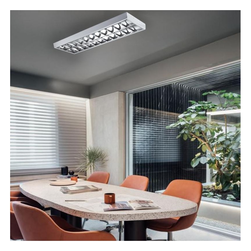 Dlhá, úzka svietidlo svieti v modernej zasadacej miestnosti. Miestnosť obsahuje oválny stôl s oranžovými stoličkami a okná s žalúziami. V pozadí je vidieť zeleň.