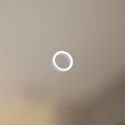 Svietiaci kruh svieti na svetlomodrom pozadí.