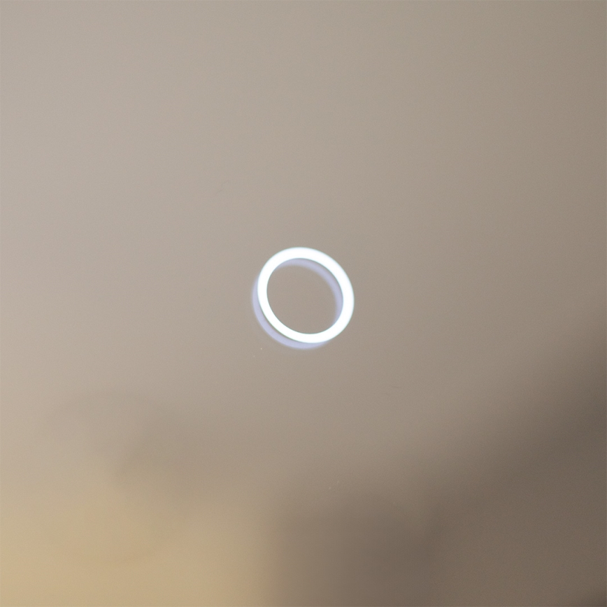 Svietiaci kruh svieti na svetlomodrom pozadí.